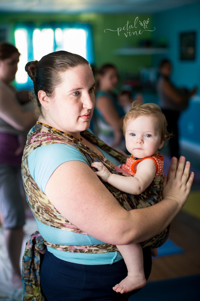 Babywearing Yoga with baby wrapped on front.