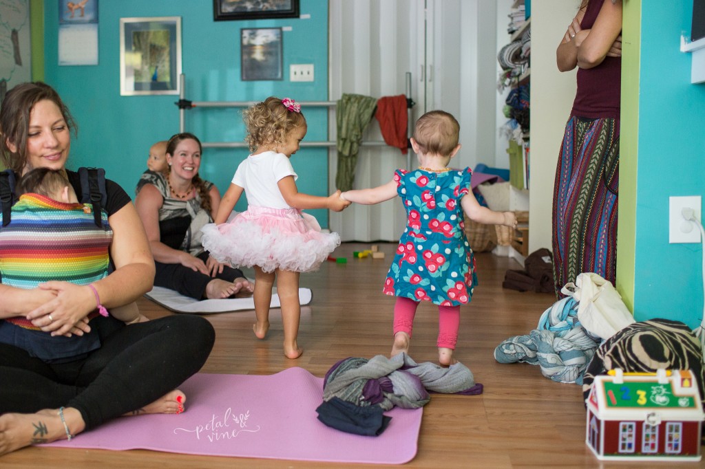 Toddlers holding hands at a yoga class.